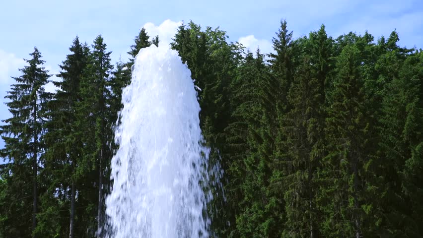 Close-up side view of fountain water jet splashes looking like geyser in city park in a sunny day. Soft focus. Real time handheld video. Urban architecture theme. | Shutterstock HD Video #1108393637