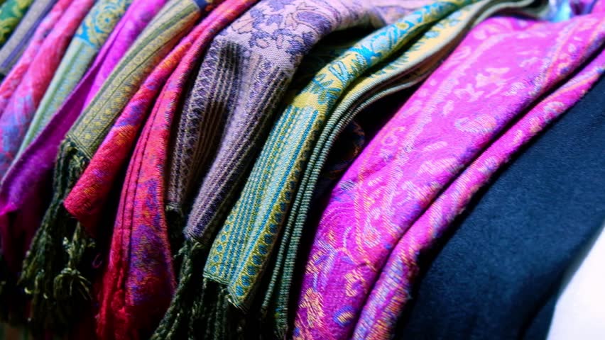 Multi-colored headscarves. Colorful middle eastern shawls. Traditional middle eastern cloth pieces folded at market stall