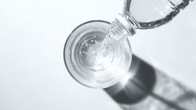 Pour bottled water into a clear glass placed on a white background. - Powered by Shutterstock - Get 15% off with code: PIKWIZARD15