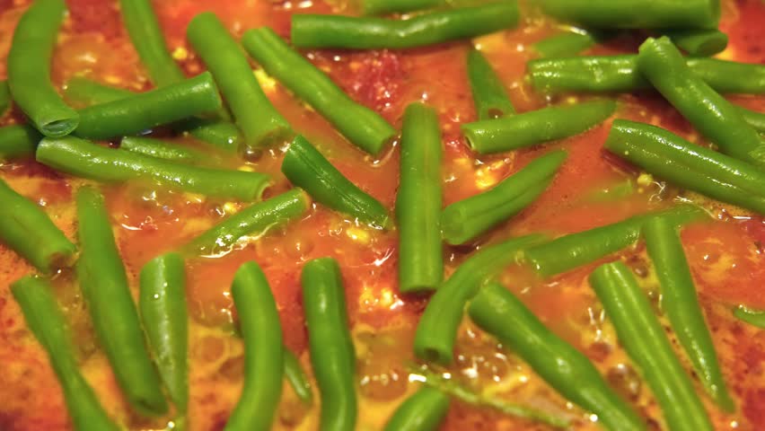 Preparation of Green bean dish. Hot Yardlong beans cooking in a pan with tomatoes, olive oil, herbs spices. French piattoni beans. Stir-fry kidney beans. Homemade Sauteed Cooked Edamame, soy. Haricots