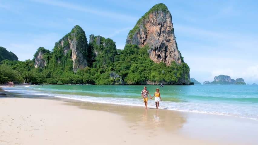 Railay Beach Krabi Thailand, the tropical beach of Railay Krabi, diverse couple of men and women on the beach walking in the morning on a sunny day, Panoramic view of idyllic Railay Beach in Thailand  Royalty-Free Stock Footage #1108403531