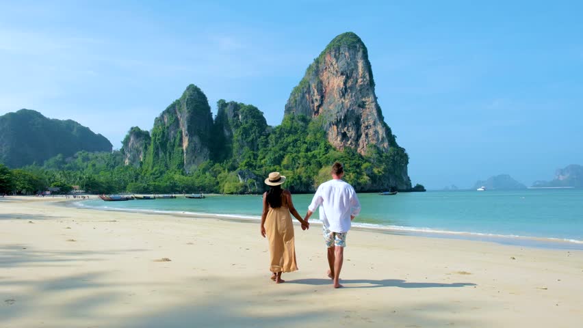 Railay Beach Krabi Thailand, the tropical beach of Railay Krabi, diverse couple of men and women on the beach walking in the morning on a sunny day, Panoramic view of idyllic Railay Beach in Thailand  Royalty-Free Stock Footage #1108403533