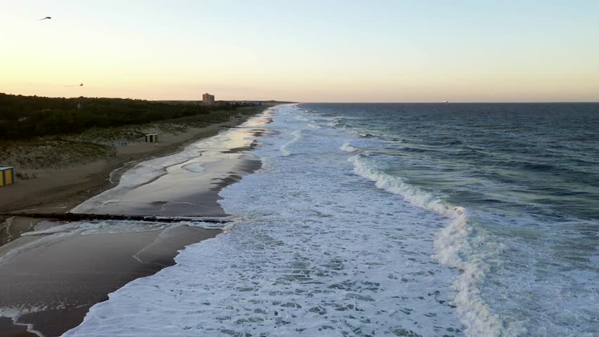 An aerial shot of the waves breaking at Rehoboth Beach, Delaware at sunset