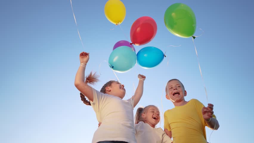 group of children jumping with balloons jumping rejoice. happy family holiday kid dream concept. children hugging jumping against the blue sky lifestyle holding balloons Royalty-Free Stock Footage #1108406159