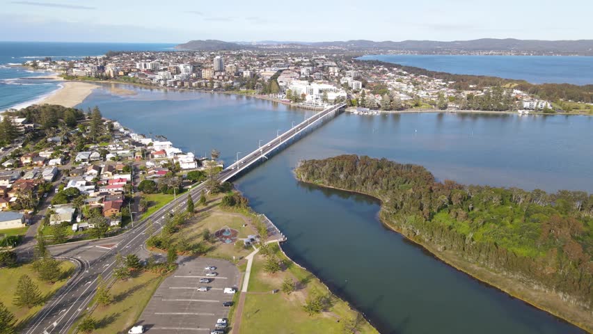 Aerial drone pullback reverse view above The Entrance and Tuggerah Lake on the Brisbane Water of Central Coast, New South Wales, Australia on a sunny morning  Royalty-Free Stock Footage #1108408397