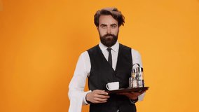 Elegant waiter carrying platter with drinks and cutlery to serve customers at five star restaurant, stylish catering employee with towel over arm. Professional worker using tray and eating tools. - Powered by Shutterstock - Get 15% off with code: PIKWIZARD15