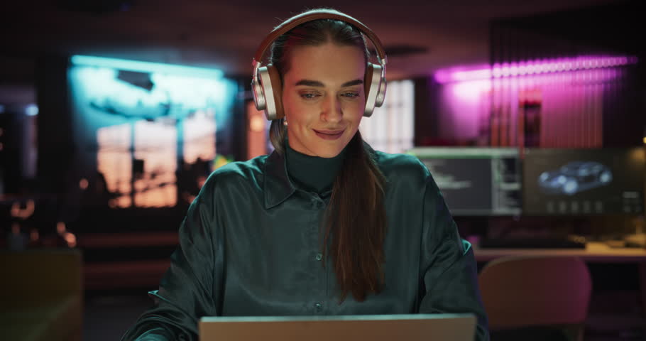 Young Project Manager with Headphones Working on Laptop Computer in Creative Office Environment. Beautiful Female Specialist is Writing Business Strategy, Using Digital Tablet to Take Notes Royalty-Free Stock Footage #1108413385