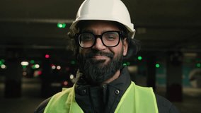 Portrait Indian man handyman worker contractor mechanic guy in helmet and glasses smiling indoors parking factory warehouse manufacture. Close up Arabian male builder engineer fitter in hard hat smile - Powered by Shutterstock - Get 15% off with code: PIKWIZARD15