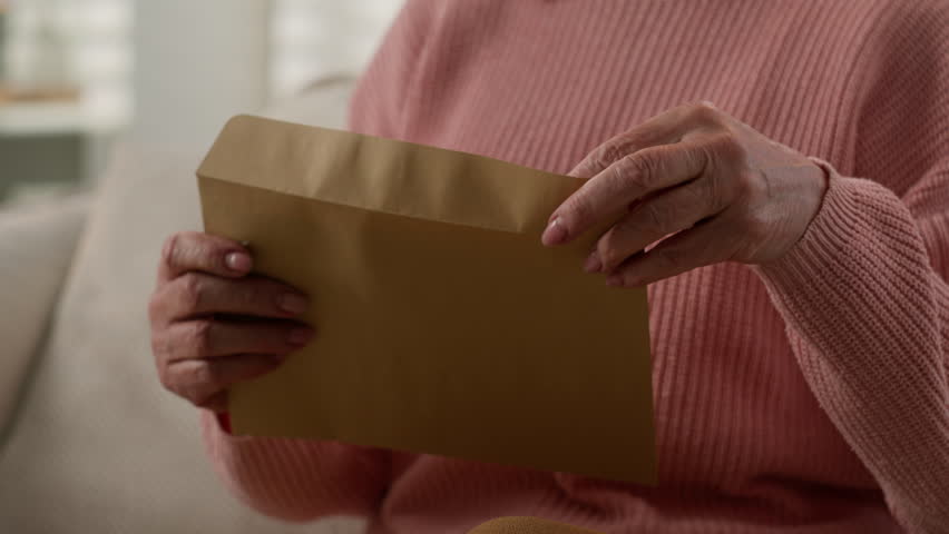 Moving shot Caucasian old woman happy grandmother retired mature senior female at home 60s lady on couch open envelope reading good news bank approval notice postal letter from family children smile Royalty-Free Stock Footage #1108419283