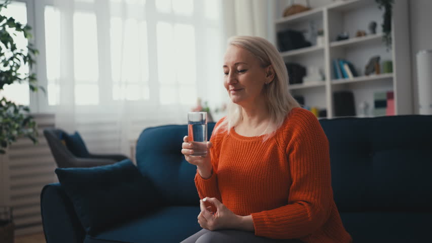 Happy middle-aged woman taking a supplement, women vitamins, body care, health Royalty-Free Stock Footage #1108421085