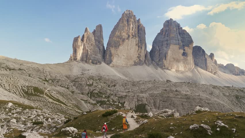 Aerial view of group of adult friends hiking Tre Cime National Park Three Peaks of Lavaredo beautiful epic mountain peaks. Travel exploring Alps Dolomites Italy nature outdoor Royalty-Free Stock Footage #1108422863
