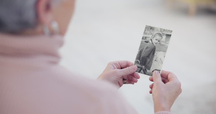 Memory, senior and woman with a photograph or hands in closeup for nostalgia in home. History, retirement and elderly person with retro photography to remember a child with grandmother in house.