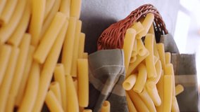 Vertical video of hand taking pasta penne basket on black table