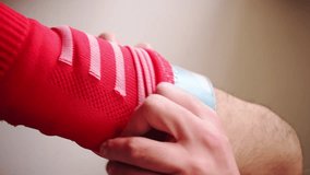 Vertical video of man wearing shin guards and red soccer socks