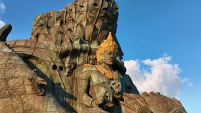 Drone video.Statue of Hindu god Garuda Vishnu Kenkhana With blue sky and clouds and sunlight in the morning located in Garuda Vesnu Kenjana Cultural Park, Bali, Indonesia.
