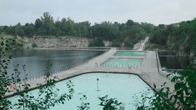 Krakow, Poland. Swimming, paddling pools, sunbathing platforms on Zakrzowek lake with steep cliffs in place of former flooded limestone quarry. New public recreational place. High quality FullHD