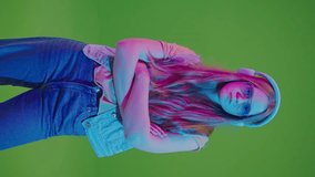 Green Screen.Vertical Video Teenage Girl Dancing In Neon Lights, Immersed In Music From Her Headphones. A Vibrant Display Of Youthful Energy And Passion For Music In A Modern, Digital Age Setting