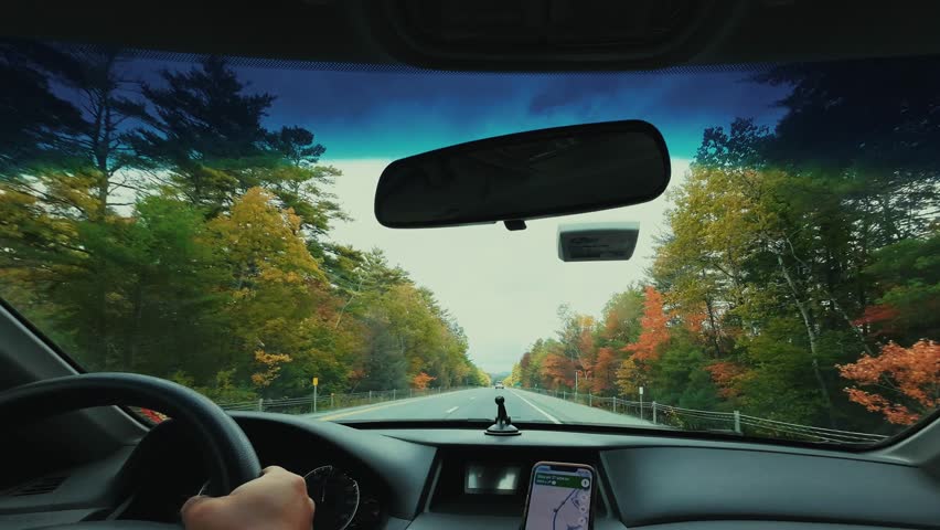 Car view of beautiful Autumn foliage with stunning nature colors on road