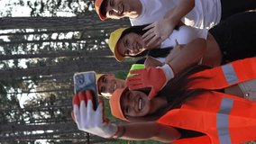 portrait of group of friends volunteers prepare to collect garbage waste and clean forest nature in summer day slow motion use mobile phone smartphone to take selfie photo or video call vertical video - Powered by Shutterstock - Get 15% off with code: PIKWIZARD15