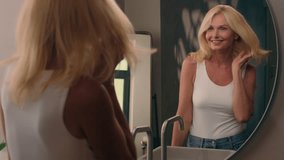 Beautiful Caucasian middle-aged mature woman go to home bathroom smile look at mirror beauty routine makeup hair care stylish haircut luxury shampoo repair balm gloss anti-aging nourishing cosmetics - Powered by Shutterstock - Get 15% off with code: PIKWIZARD15