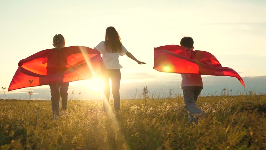 Superhero girl boy mother play green grass. concept cute happy family being green field sunset. family winners together friend. superhero concept. happy superhero family jogging outdoors red raincoat. | Shutterstock HD Video #1108452215