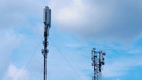 View of cell tower antennas on the blue sky and clouds background. Timelapse. Telecommunication cell phone, radio transmitters of cellular 6g 5g 4g mobile, smartphones, internet. IT. Video Footage 4k.
