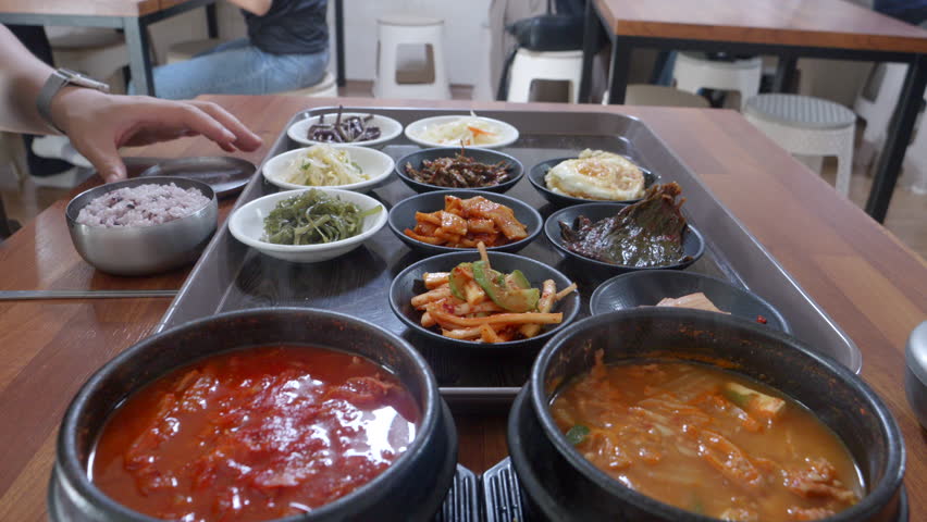 Eating Korean food with lots of side dishes, kimchi stew, and cheonggukjang Royalty-Free Stock Footage #1108455235