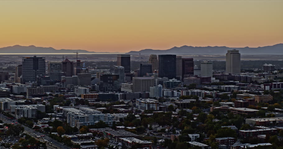 Salt Lake City Utah Aerial v30 panning west view capturing downtown cityscape with orange glowing sun setting in the background with red sensor flare - Shot with Inspire 2, X7 camera - October 2021