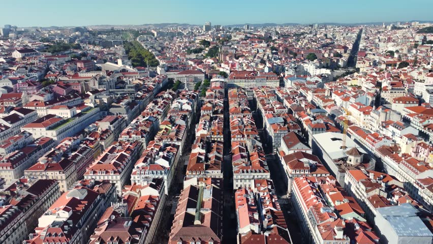 Aerial view of Lisbon - Portugal. Drone going backward above the city center and Commerce Square. Rooftops of Lisbon. Travel destination and capital city visited annually by many foreign tourists. Royalty-Free Stock Footage #1108461161