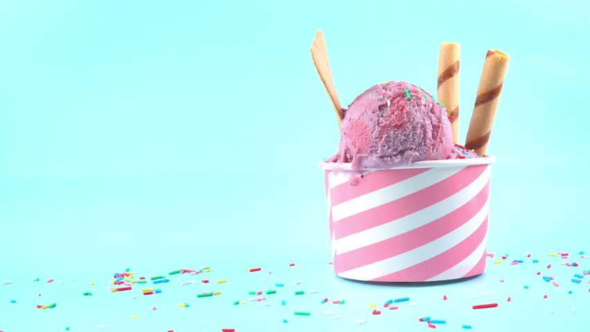 scoops of berries ice cream in bowl with strewed sprinkles, cigars and cookies on blue background, summer creative concept, copy space Royalty-Free Stock Footage #1108473659