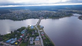 Top view of road across river in town. Clip. Beautiful landscape of city divided by strait with land highway. Highway connecting city strait on summer day