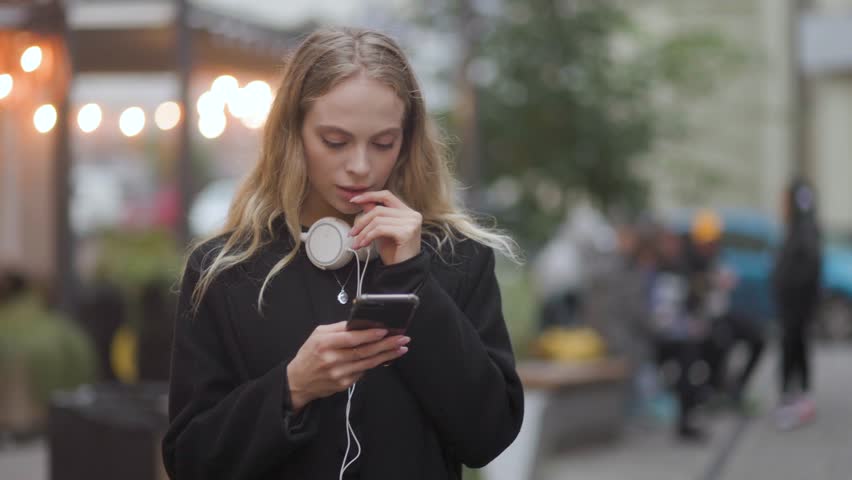 Pretty young blond woman in the evening city centre get notification and celebrate online win success reading great news message feel amazed happy outdoors Royalty-Free Stock Footage #1108476041