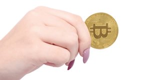 Hands holds and shows two golden cryptocurrency bitcoin on white background. Movement towards the viewer. Macro zoom. Top view. 4K UHD video footage 3840X2160.