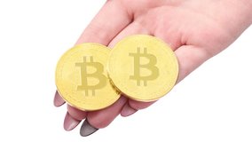 Hands holds and shows two golden cryptocurrency bitcoin on white background. Movement towards the viewer. Macro zoom. Top view. 4K UHD video footage 3840X2160.
