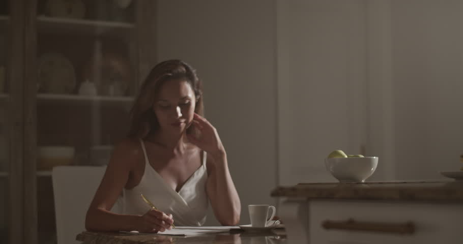 Smiling female composer writing in notebook while composing music