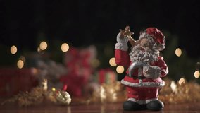 Christmas decoration on a wooden table with a Santa Claus doll, small gifts, and colorful flashing lights. Christmas decoration background. Theme video collection.
