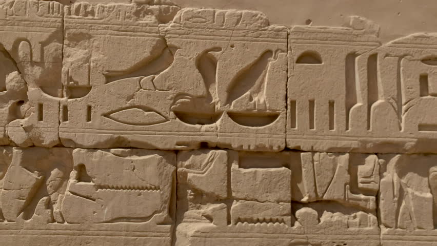 Wall of hieroglyphics at Karnac temple, Egypt. Strong carved relief of the symbols important to the ancient Egyptian culture. Day.
