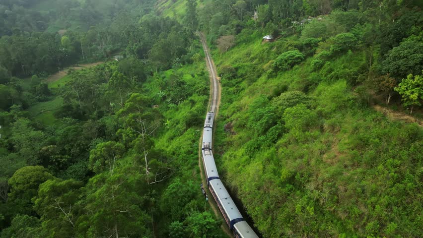 Aerial view of Nine Arch bridge in mountain jungle of Sri Lanka. Train keep going.  Drone following for train inside jungle Royalty-Free Stock Footage #1108484597