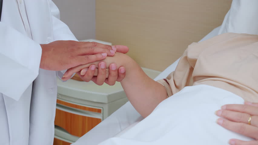 Closeup hands of doctor man encourage with elderly patient at the hospital, physician take care and holding hands for consoling senior sick, diagnostic disease and illness, medical concept.