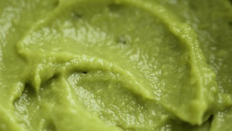 Fresh avocado cream. Guacamole paste of mashed green fruits. Healthy food. Macro shot. Rotation Adlı Stok Video