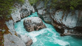 Mountain river Soča in Triglav National Park Slovenia, alps, forest trees, nature. Blue water is rushing through a canyon with waterfall cascade and rocks in slow motion. Cinemagraph seamless video 4K