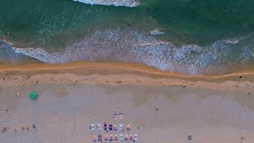Landscape of My Khe beach, Da Nang, Vietnam with people practicing yoga, walking for exercise and waves in the morning filmed from above.  Beach and people.  Travel concept, ocean sea background.