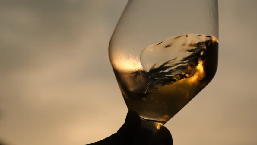pouring white wine into a wine glass as sunsets, close up, fa01 Royalty-Free Stock Footage #1108496007