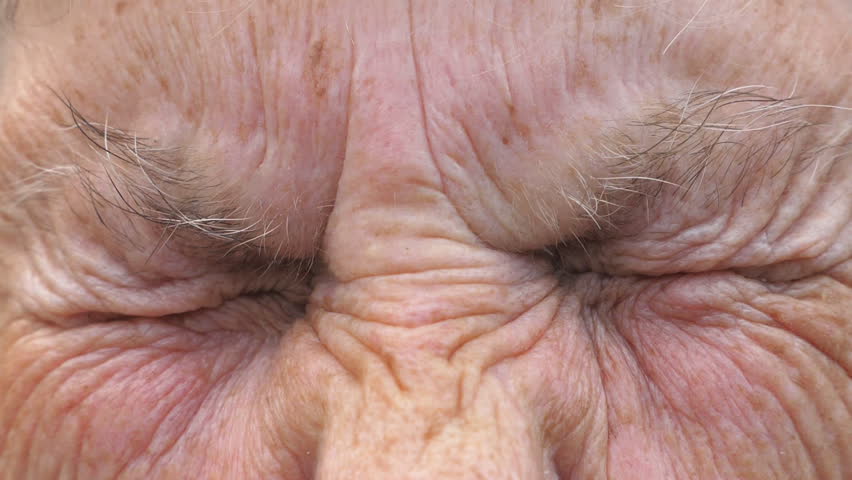 Portrait of mature woman screwing up her gray eyes and then open. Close up wrinkled face of old grandmother looking into camera with a sad sight. Sorrow facial expression of senior lady. Slow motion Royalty-Free Stock Footage #1108496779