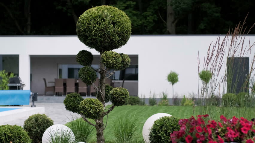 Front yard, landscape design With multicolored shrubs intersecting with bright green lawns Behind the house is a modern, garden care service, green grass with a beautiful yard for the background. Royalty-Free Stock Footage #1108498169