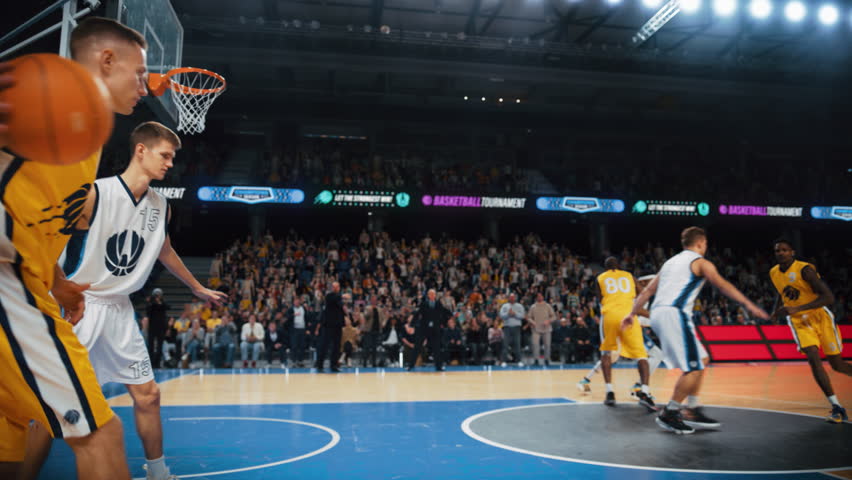 Slow Motion Replay of a Basketball Match in an Arena. Player Catching a Ball From a Teammate, Running to Score an Impressive Two-Point Goal with a Slam Dunk. Cinematic Sports Channel Footage Royalty-Free Stock Footage #1108499919