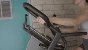 This video shows a close up view of a woman's arms on the handles of a cardio stair machine.