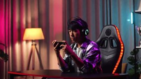 Excited Asian Teen Boy Gamer Playing Video Game On Smartphone
