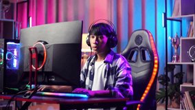 Excited Asian Teen Boy Gamer Celebrates Victory And Dancing While Playing Video Game On Computer
