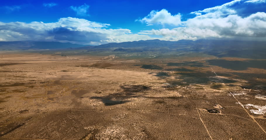 Amazing scenery of a desert in California. Dry lifeless landscape of Death Valley under the azure sky with white clouds. Top view.